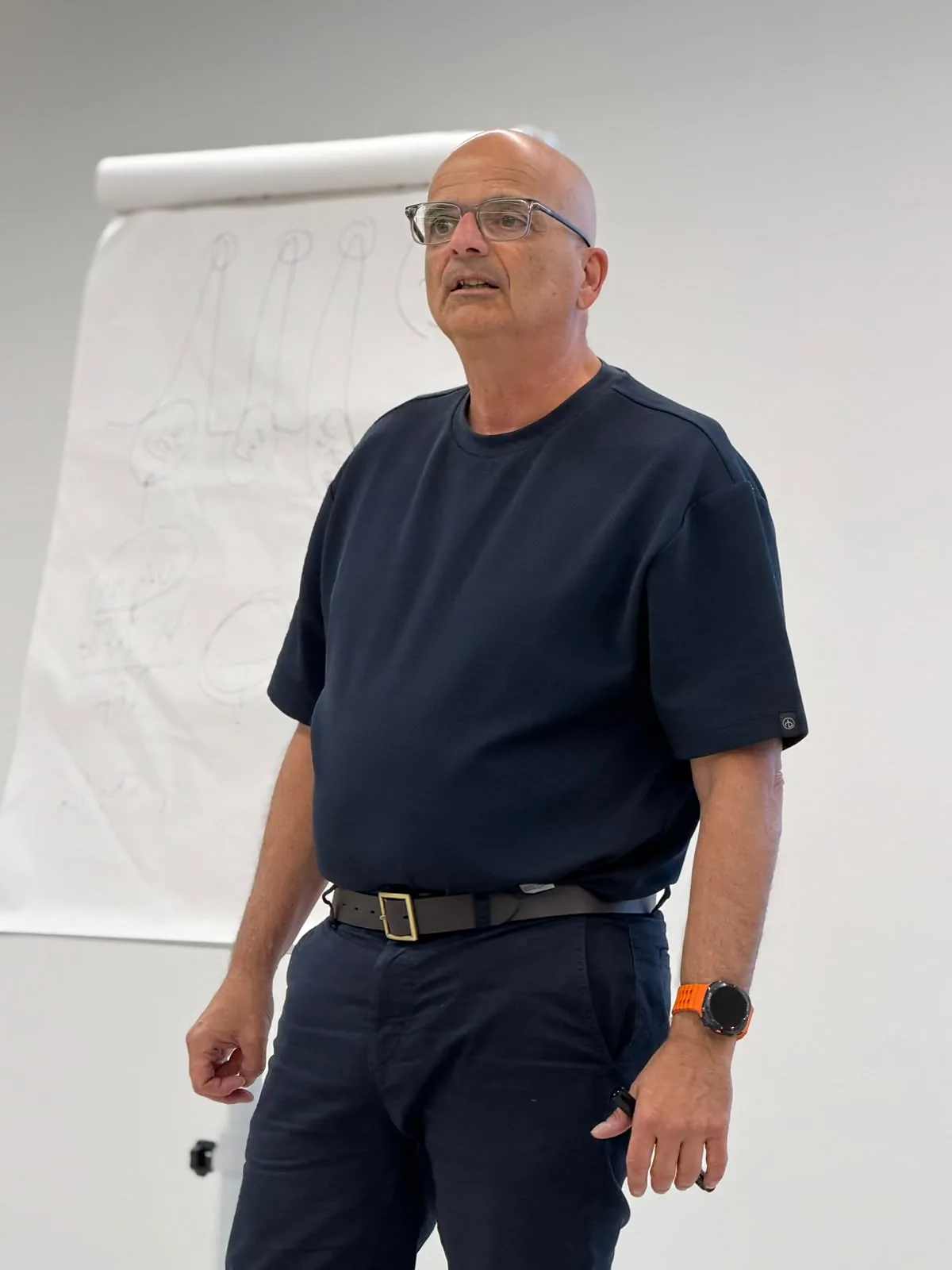 איציק חיקי מרצה ליד לוח הדפדפת בהדרכת מכירות לצוות הנציגים של צ'מפיון מוטורס